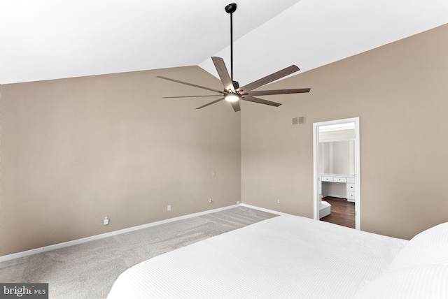 unfurnished bedroom featuring high vaulted ceiling, carpet flooring, baseboards, ceiling fan, and ensuite bath