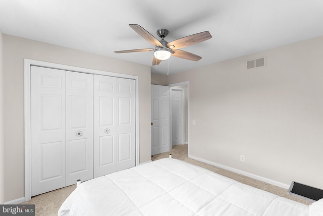 bedroom with light colored carpet, baseboards, and a closet