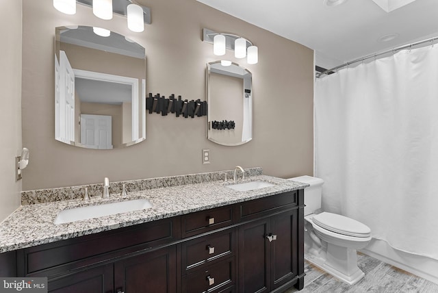 bathroom with toilet, wood finished floors, double vanity, and a shower with shower curtain