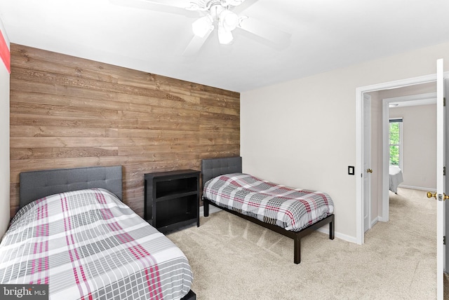 bedroom featuring wood walls, carpet, baseboards, and a ceiling fan