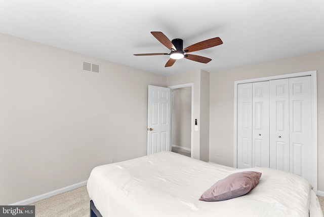 bedroom featuring baseboards, light colored carpet, and a closet