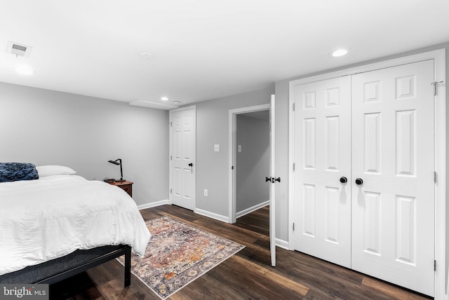bedroom with baseboards, wood finished floors, recessed lighting, and a closet