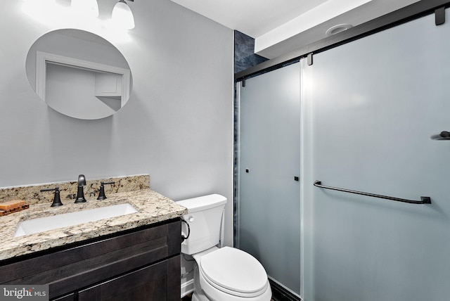 full bathroom featuring toilet, vanity, and an enclosed shower