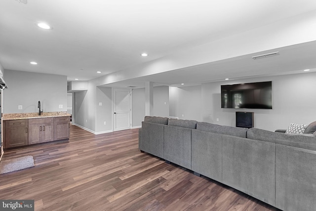 living room with dark wood-type flooring, recessed lighting, and baseboards