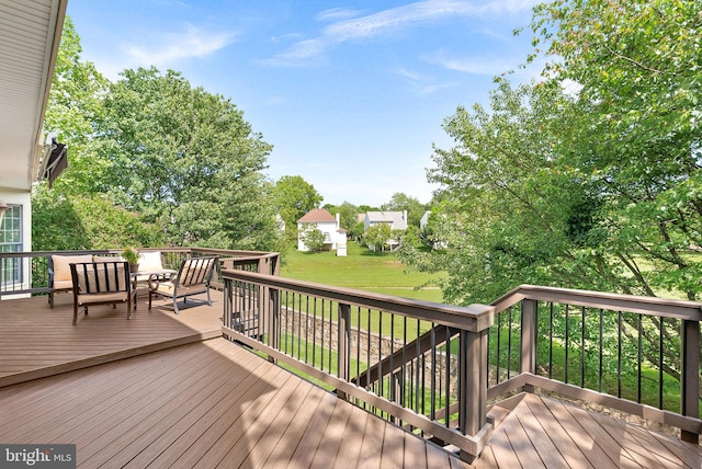wooden terrace featuring a lawn