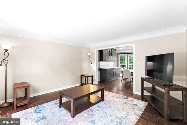living room with crown molding, dark wood-style flooring, and baseboards