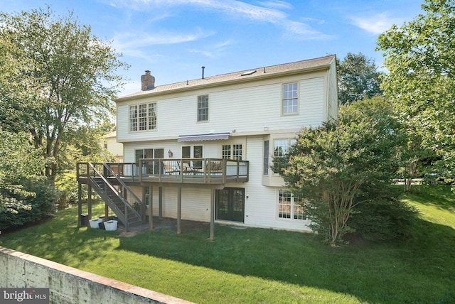 rear view of property with a deck, stairs, a chimney, and a lawn