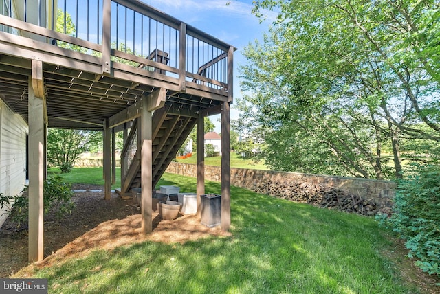 view of green lawn with a deck and stairs