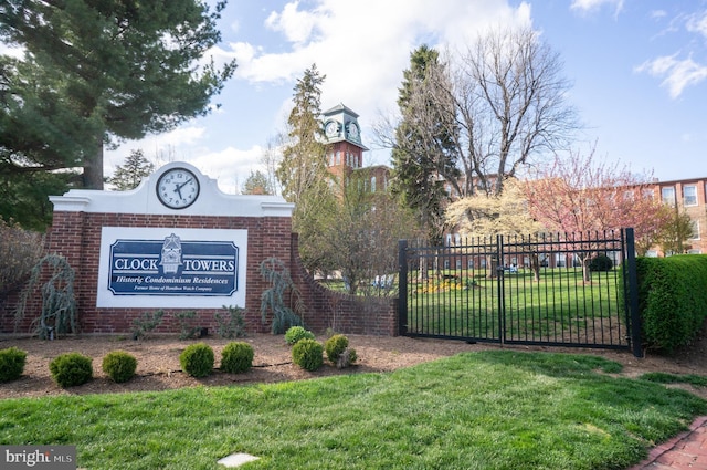community sign with a yard, a gate, and fence