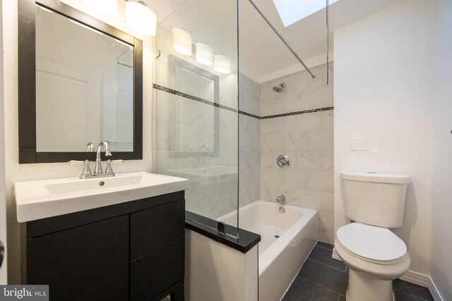 bathroom with a skylight, tile patterned flooring, toilet, shower / bath combination, and vanity
