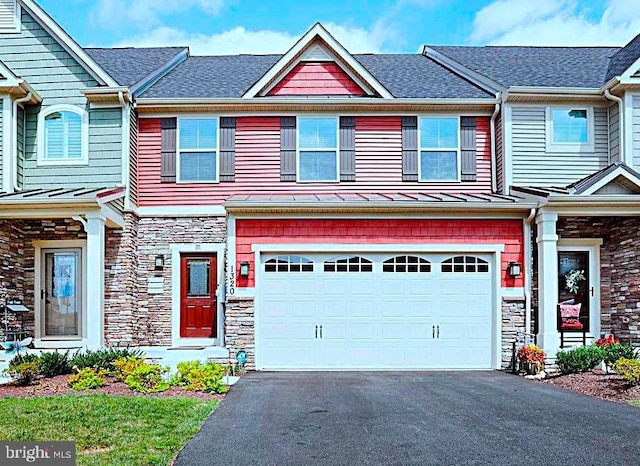 view of property with a garage, aphalt driveway, stone siding, and a shingled roof