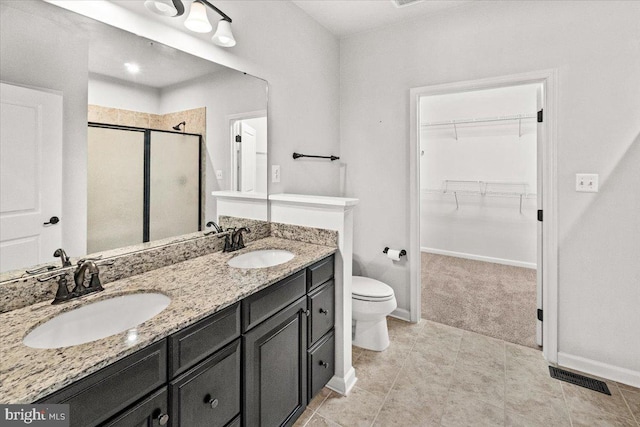 bathroom with visible vents, a sink, a walk in closet, and a stall shower