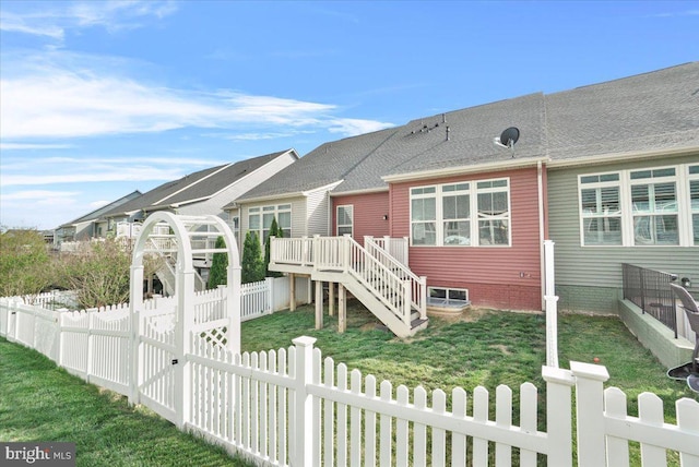 back of house featuring a lawn, fence private yard, a deck, and stairway