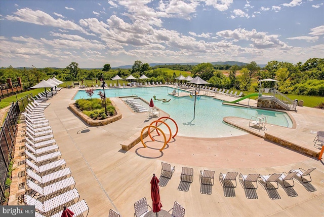 community pool with fence and a patio area