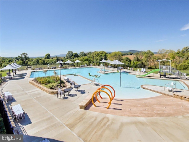 community pool with a patio and fence