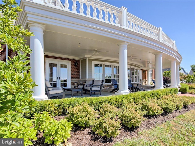 rear view of property featuring brick siding, a ceiling fan, french doors, and a patio