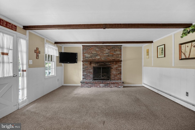 unfurnished living room with carpet floors, a baseboard radiator, wainscoting, a brick fireplace, and beam ceiling