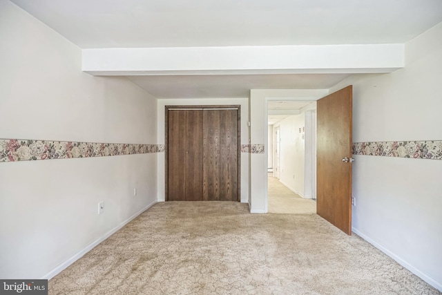 unfurnished bedroom featuring baseboards, a closet, and carpet flooring