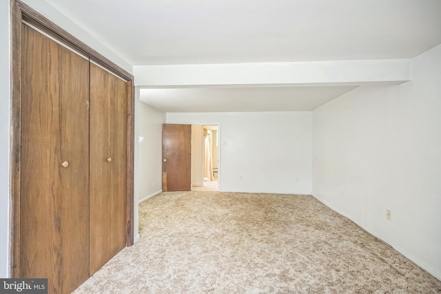 unfurnished bedroom with a closet and light carpet