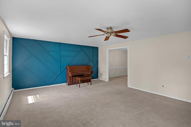 sitting room with carpet floors, a decorative wall, baseboard heating, baseboards, and a ceiling fan