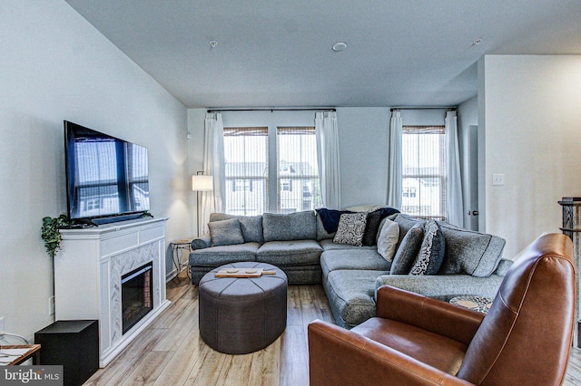 living room with light wood-style floors and a premium fireplace