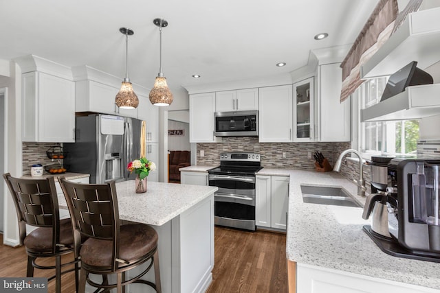 kitchen with stainless steel appliances, white cabinets, dark wood-style floors, and a sink