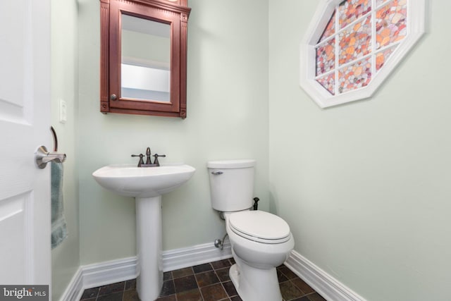 bathroom featuring toilet and baseboards
