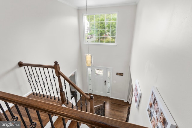 foyer with crown molding, stairway, wood finished floors, and baseboards