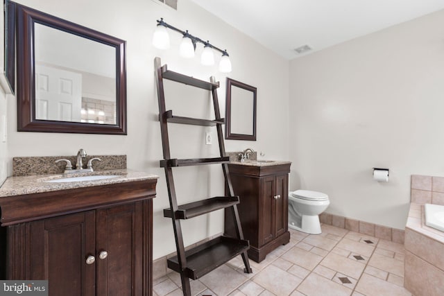 bathroom with tiled tub, a sink, visible vents, baseboards, and two vanities