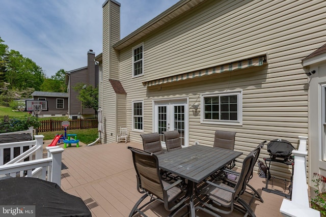 wooden terrace with fence, outdoor dining area, and french doors