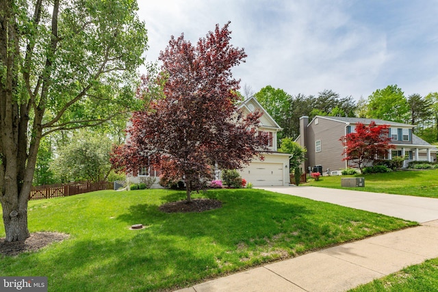 obstructed view of property featuring a garage, fence, a front lawn, and concrete driveway