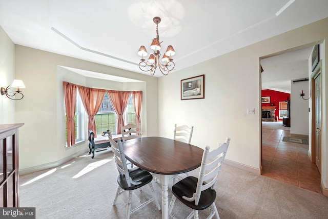 carpeted dining room with baseboards, tile patterned floors, and a chandelier