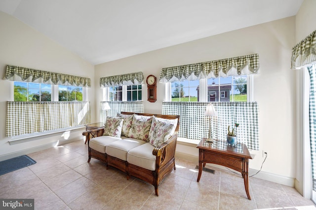 living room with baseboards, visible vents, light tile patterned floors, and lofted ceiling