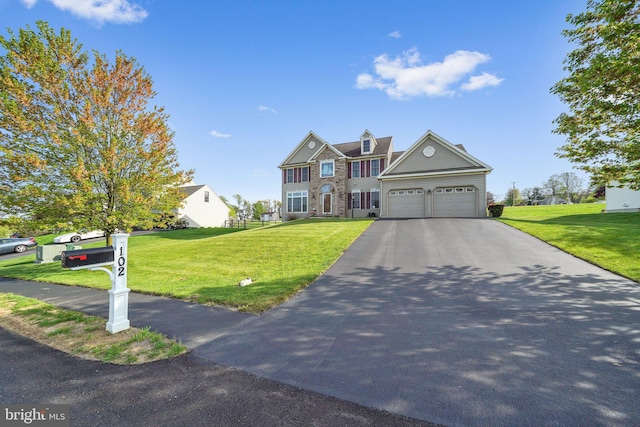 view of front facade with a garage, a front lawn, and driveway