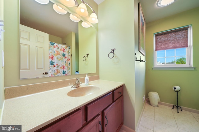 bathroom with baseboards, tile patterned floors, and vanity