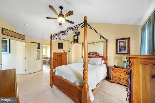 bedroom with connected bathroom, light colored carpet, and vaulted ceiling