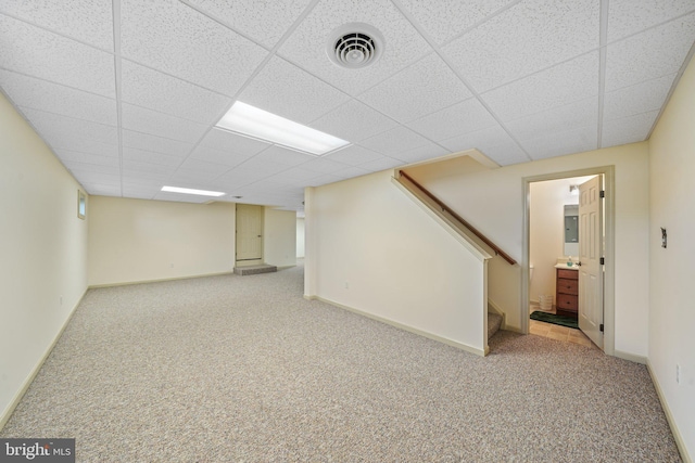 finished below grade area featuring stairway, carpet flooring, a drop ceiling, and visible vents