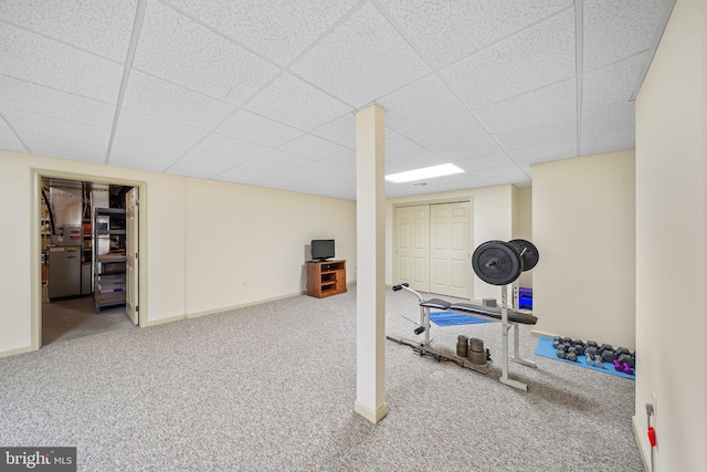 workout room featuring baseboards, carpet, and a drop ceiling