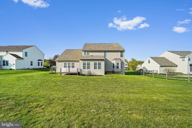 back of property with a wooden deck and a yard