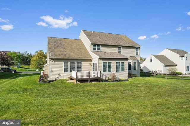 back of property featuring a wooden deck and a yard