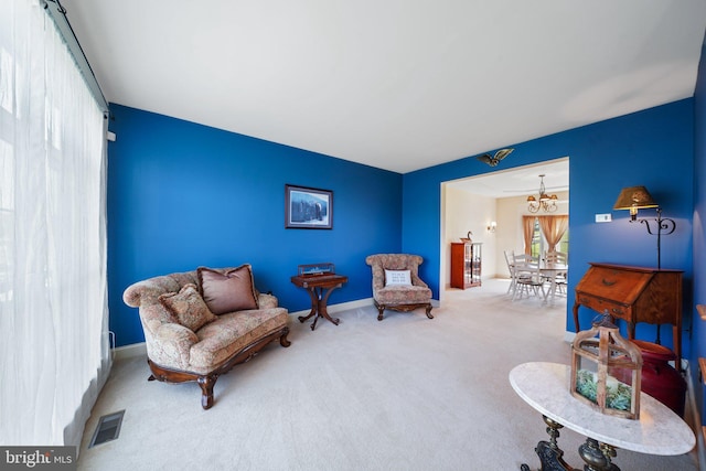 sitting room with carpet floors, a notable chandelier, visible vents, and baseboards