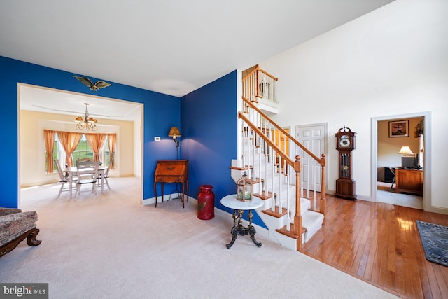 interior space featuring baseboards, an inviting chandelier, wood finished floors, and stairway