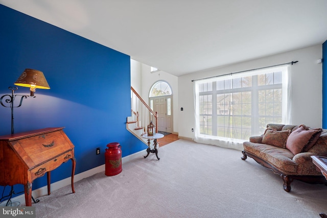 living area featuring stairway, baseboards, and carpet