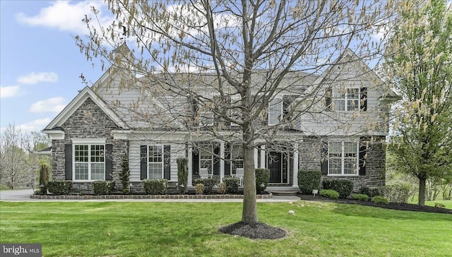 view of front of house featuring a front lawn and stone siding