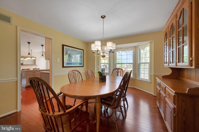 dining room featuring visible vents, a notable chandelier, dark wood-style floors, and baseboards