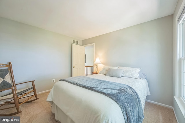 bedroom featuring baseboards, visible vents, and light colored carpet