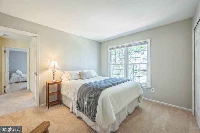 bedroom featuring baseboards and light carpet