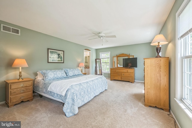 carpeted bedroom with baseboards, visible vents, a ceiling fan, and multiple windows