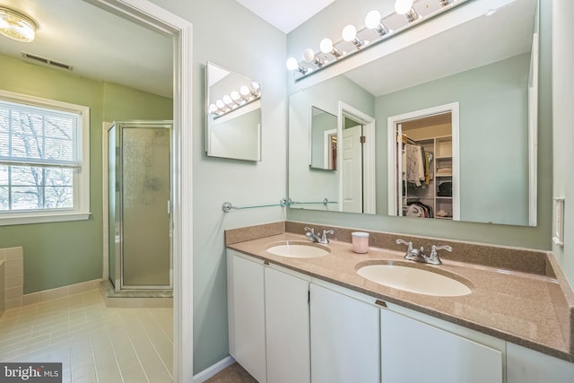 bathroom with visible vents, a shower stall, tile patterned flooring, and a sink