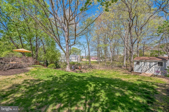 view of yard with an outbuilding, a shed, and fence